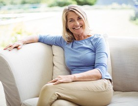 Confident, smiling senior woman sitting on sofa