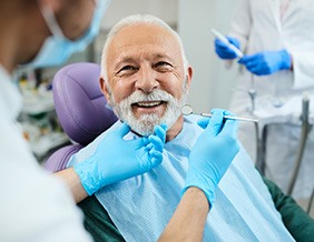 Older man learning about dentures at the dentist’s office