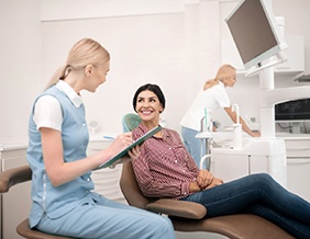 Woman smiling at dentist assistant during appointment